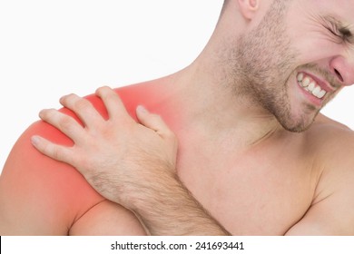 Closeup Of Young Shirtless Man With Shoulder Pain Over White Background