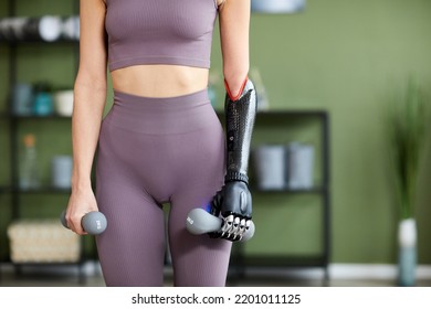 Close-up Of Young Slim Woman Holding Dumbbells With Prosthetic Arm During Training At Home