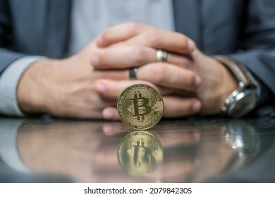 Closeup Young Unrecognizable Businessman In Formal Wear With A Bitcoin BTC Gold Coin In Front Of Him. Cropped Photo Banner For Website Header Design. Holder, Long Term Investment Concept.