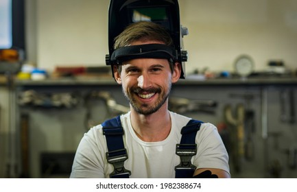 Close-up of the young welder with the welding mask. The worker in the protective mask. Portrait, man, welding