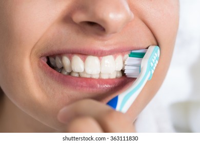 Closeup Of Young Woman Brushing Teeth At Home