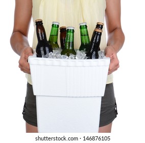 Closeup Of A Young Woman Carrying A Styrofoam Ice Chest, Over A White Background. Cooler Is Full Of Ice And Beer Bottles. Woman Is Unrecognizable.