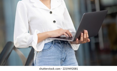 Close-up Of A Young Woman In The City Using A Laptop Computer Outside The House.