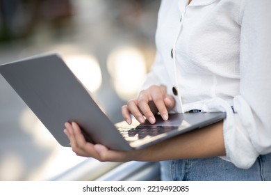 Close-up Of A Young Woman In The City Using A Laptop Computer Outside The House.