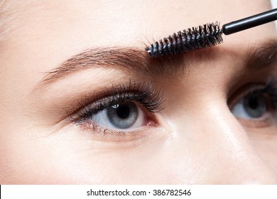 Closeup Of A Young Woman Doing Makeup Eyebrow Brush