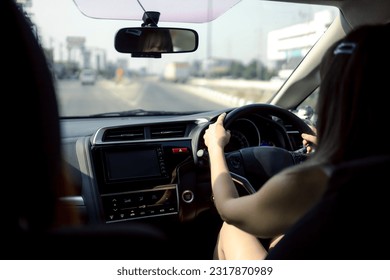 Close-up of Young woman driving on the road - Shutterstock ID 2317870989