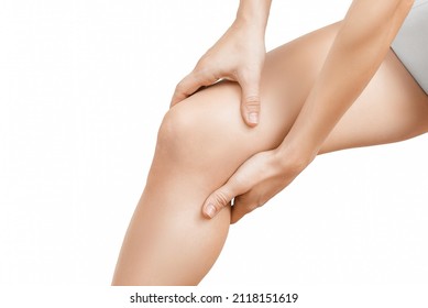 Closeup young woman feeling knee pain and she massage her knee. Healthcare and medical concept. Close-up painful knee. Close up of female hands holding knee. - Shutterstock ID 2118151619