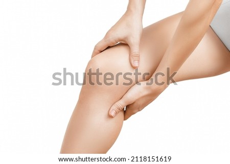 Closeup young woman feeling knee pain and she massage her knee. Healthcare and medical concept. Close-up painful knee. Close up of female hands holding knee.