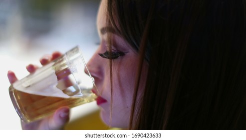 
				Closeup of young woman hand using cellphone touchscreen while drinking alcholic beverage at bar nightlife