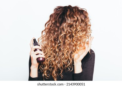 Close-up Young Woman Holding Her Curly Brown Hair Applying Moisturizing Oil