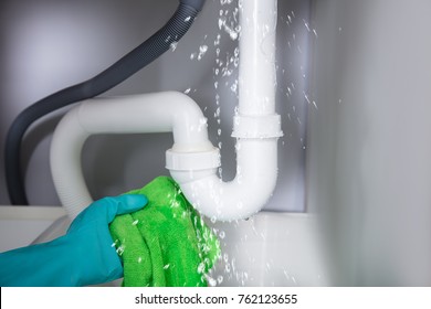 Close-up Of A Young Woman Holding Napkin Under Sink Pipe Leakage