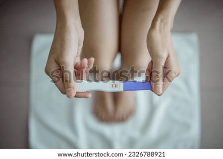 Close-up of young woman holds a pregnancy test in her hands. Positive pregnancy test.
