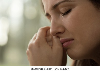 Close-up of young woman with problems crying