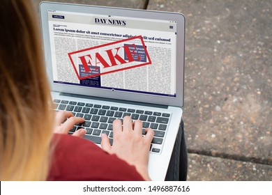 Closeup Of Young Woman Reading Digital Fake News On Laptop. Propaganda And Disinformation Online. Media And Digital Concept. All Screen Graphics Are Made Up By Us

