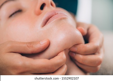 Close-up Of A Young Woman Receiving Chin And Jawline Face Lifting Massage