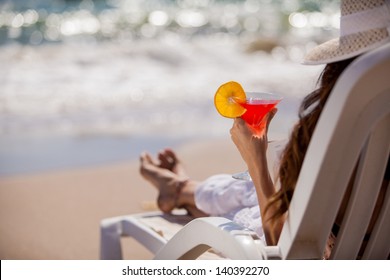 Closeup of a young woman relaxing at the beach with a cold martini
