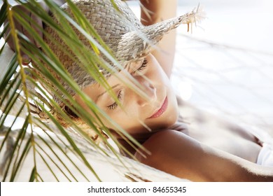 closeup of young woman relaxing in a hammock by the beach - Powered by Shutterstock