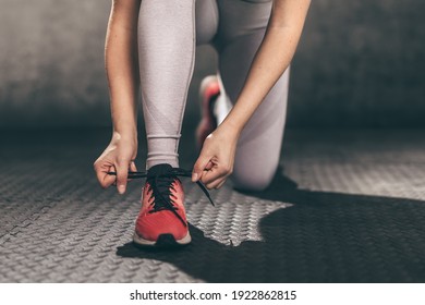 Closeup of young woman runner tying her shoelaces. - Powered by Shutterstock