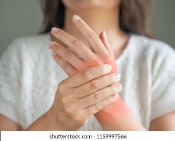Closeup young woman sitting on sofa holds her wrist. hand injury, feeling pain. Health care and medical concept.
