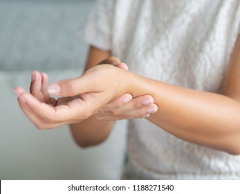 Closeup young woman sitting on sofa holds her wrist. hand injury, feeling pain. Health care and medical concept. - Shutterstock ID 1188271540