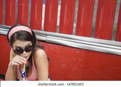 Closeup Of A Young Woman In Sunglasses Drinking Soda