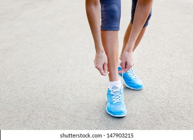 Closeup of Young Woman Tying Sports Shoe - concept image - Powered by Shutterstock