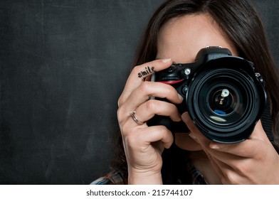 Closeup Of Young Woman Using Camera Over Gray Background - Powered by Shutterstock