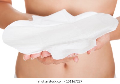 Close-up Of Young Woman Wearing Lingerie Holding Sanitary Pad Over White Background