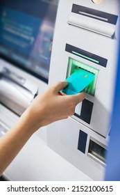 Close-up of a young woman's hand inserting a credit card into an ATM bank machine to transfer money or withdraw. Finance customer and banking service concept. Vertical shot - Shutterstock ID 2152100615