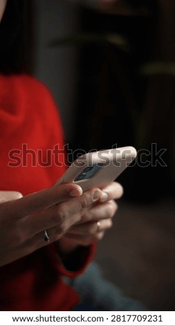 Close-up of a young woman's hands using a smartphone at home, highlighting mobile technology, digital communication and everyday connected lifestyle.