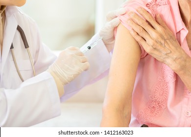 Closeup,asian Female Doctor With Syringe Doing Injection Vaccine,flu,influenza In The Shoulder Of Senior Woman,young Nurse Injecting,vaccinating Elderly Patient,vaccination,medicine,healthcare Concept