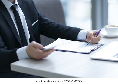 closeup.businessman checking financial statement,sitting at the Desk - Shutterstock ID 1298450299