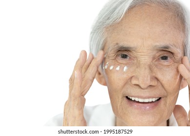 Close-up;Face of asian senior woman applying eye cream;anti-aging;nourishing under eye;facial treatment;happy smiling old elderly removing wrinkles crow's feet surrounding their eyes;skin care concept