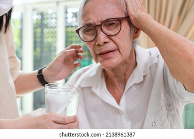 Closeup,glass Of Water With Ice,senior Grandmother With A Brain Freeze After Drinking Cold Water,severe Pain In Her Head,Asian Elderly Woman Getting Brain Freeze,health Care,food And Drinks Concept