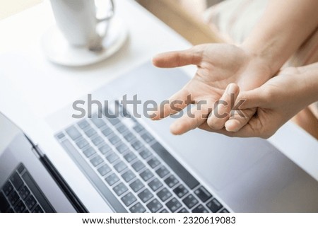 Close-up,Hand of asian woman massaging her palm,suffering from trigger finger disease,tendon problem,pain in hand and fingers,trigger finger from typing on keyboard for long period of time,health care