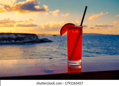 Closeupp on a cold Paloma cocktail against the setting sun on the beach. - Powered by Shutterstock