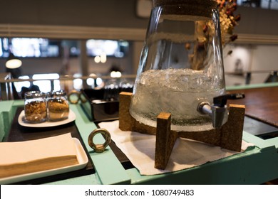 Close-ups Of Beverage Bar Counter Convenience For Customer Such As Iced-water, Sugar, Creamer And Paper Napkin At Coffee Cafe Shop In The Afternoon For Tea Time In Relaxing Moon On Sunday.