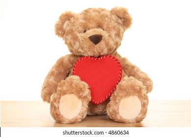 close-ups of cute teddy bear with big heart isolated on white