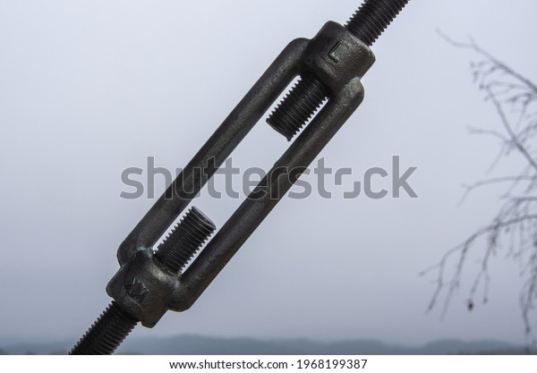 Closeup-Turnbuckles that pull the rope in front of\
grey sky, Copy\
Space