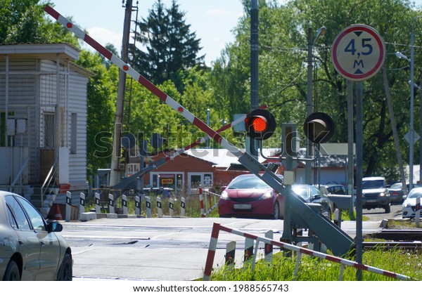 Closing of a barrier in\
front of cars due to an approaching train. Crossroads of road and\
railways. 