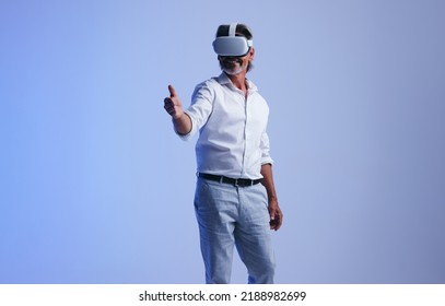 Closing business deals in the metaverse. Senior businessman giving a virtual handshake to a business partner. Successful businessman wearing a virtual reality headset in a studio. - Shutterstock ID 2188982699