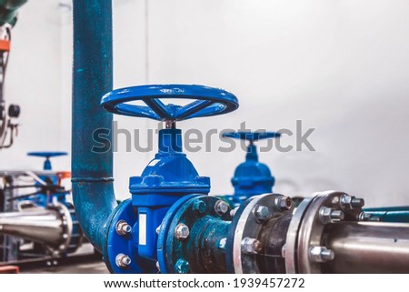Closing valve on water pump station is pipeline with water tanks in an industrial room for supply of high-pressure water. Water sprinkler pipes and pressure control system. Copy space for site