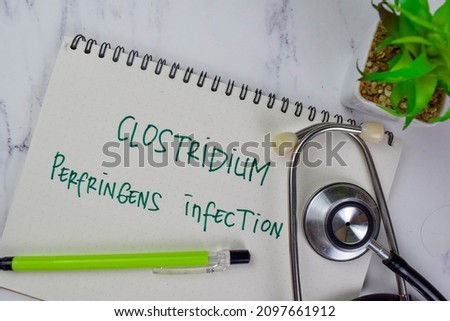 Clostridium Perfringens Infection write on a book isolated on Wooden Table.