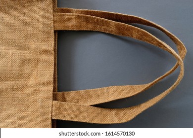 A cloth bag made of jute fiber, closeup view, colored texture background. Jute made bags are reusable and biodegradable, an ideal replacement for plastic bags. A sustainable environmental choice. - Powered by Shutterstock