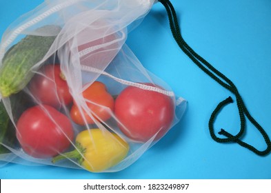 Cloth Bag With Organic Vegetables On Blue Background. Plastic Free, Zero Waste Shopping And Living. Reusable, Recycled, Homemade Produce Bag For Fruit Or Vegetables, A Textile Bag.