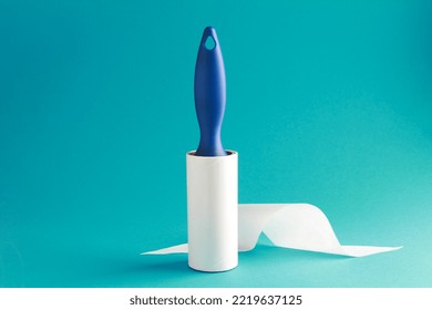 Cloth fabrics cleaner lint roller brush with paper roll blue grip on mint green blue color background. sticky roller, pet cat dog fur dust hair remover - Powered by Shutterstock