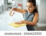 Cloth, spray and child cleaning table in home for hygiene, chores or housekeeping maintenance. Girl, kid or wipe kitchen counter to disinfect for learning housework, education or help for development