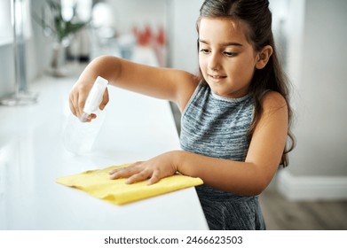 Cloth, spray and child cleaning table in home for hygiene, chores or housekeeping maintenance. Girl, kid or wipe kitchen counter to disinfect for learning housework, education or help for development - Powered by Shutterstock