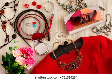 Clothes and accessories. Red dress, leather purse, sunglasses, belts for clothes, ladies' mirror, jewelry are needed to create a fashionable style. View from above. Design and accessories.