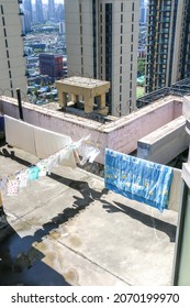 Clothes and bed sheets drying in the sun on the top floor of apartment building